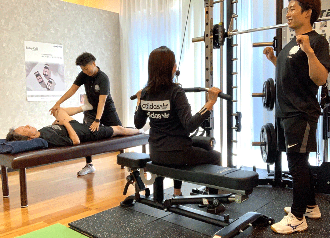 トレーナーと利用者が両手を広げストレッチする様子